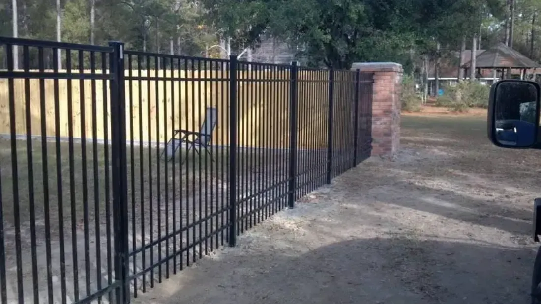 Black aluminum fence with brick columns